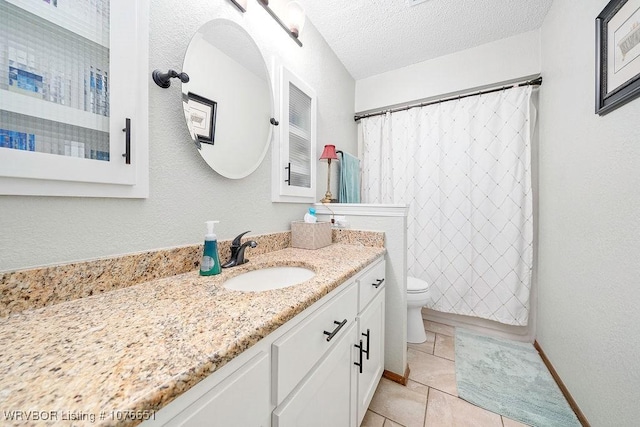 bathroom with tile patterned flooring, vanity, toilet, and a textured ceiling