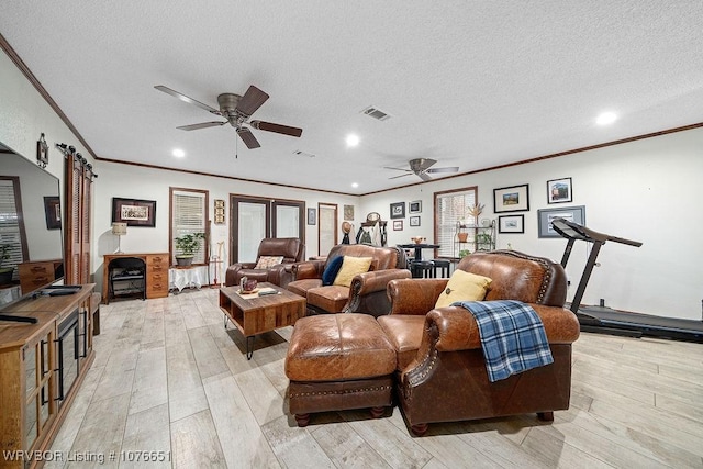 living room featuring crown molding, ceiling fan, light hardwood / wood-style floors, and a textured ceiling