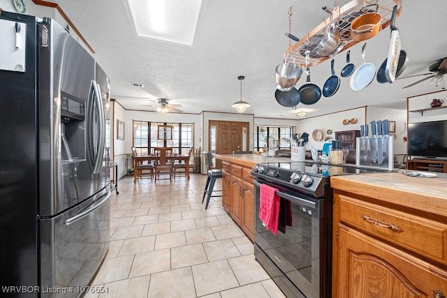 kitchen with light tile patterned floors, black range with electric stovetop, stainless steel refrigerator with ice dispenser, a textured ceiling, and decorative light fixtures