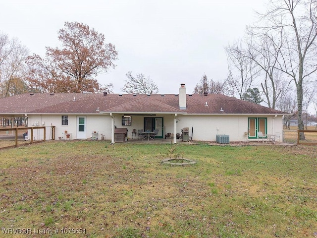 rear view of property featuring a yard and central air condition unit