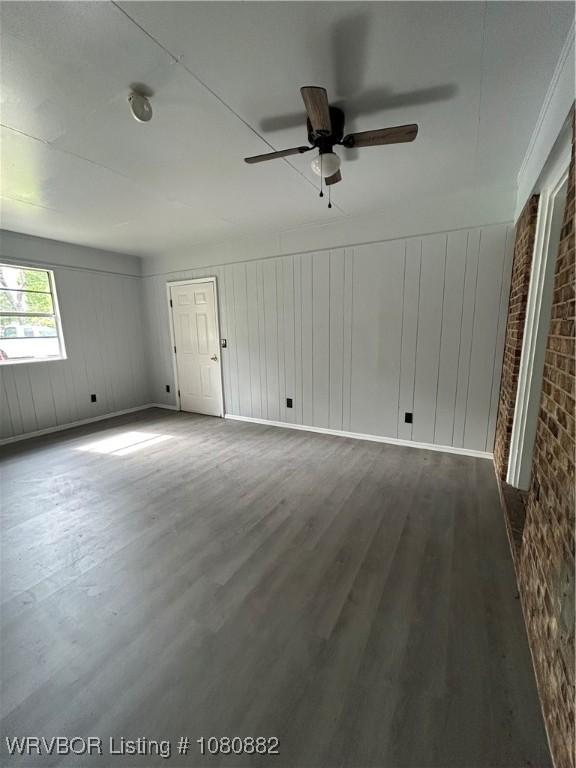 614 N School St, Charleston, AR 72933 - empty room with wood finished floors, ceiling fan, and a decorative wall