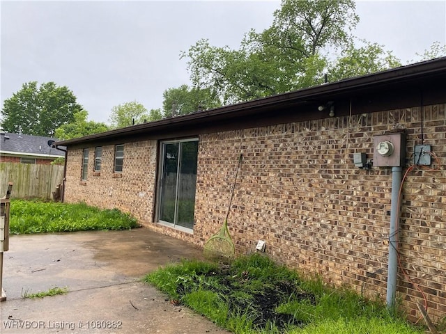 614 N School St, Charleston, AR 72933 - view of property exterior with a patio area, fence, and brick siding