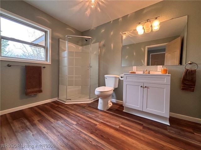 full bathroom featuring baseboards, a shower stall, toilet, and wood finished floors