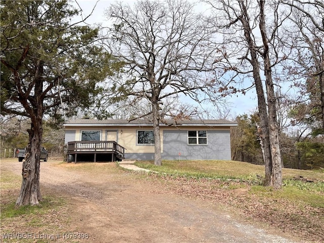 view of front of home featuring driveway and a wooden deck