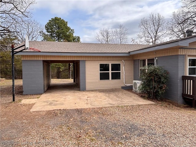 back of property featuring a shingled roof and dirt driveway