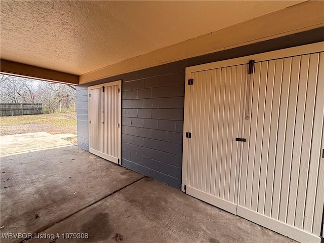 view of exterior entry featuring a patio area and fence