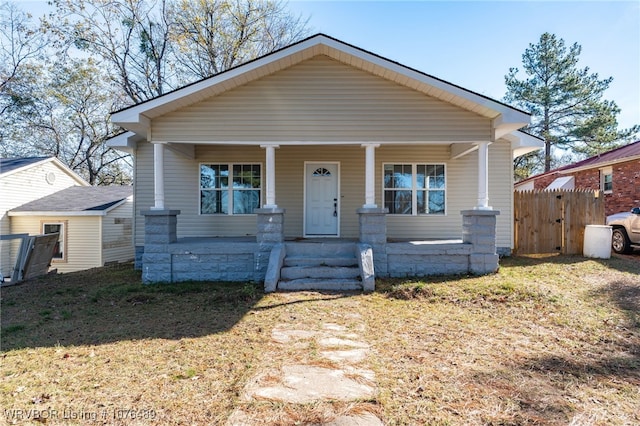 bungalow featuring covered porch and a front lawn