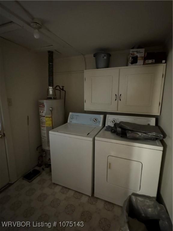 laundry room with washing machine and dryer, water heater, and cabinets