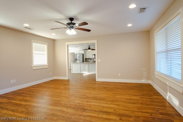 unfurnished living room with light wood-type flooring and ceiling fan