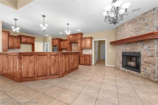 kitchen featuring a fireplace, stainless steel oven, light tile patterned floors, decorative light fixtures, and a chandelier