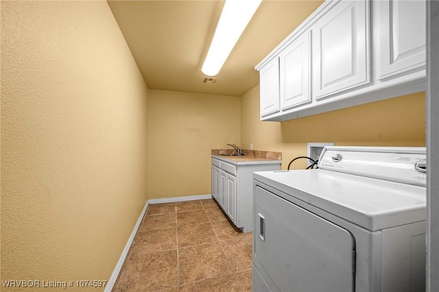 clothes washing area featuring cabinets, washer / dryer, and sink