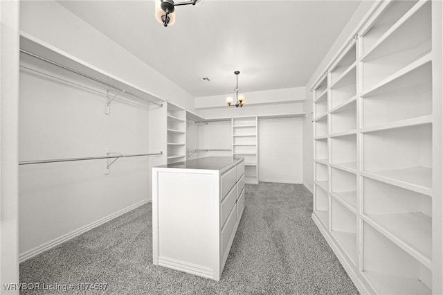 spacious closet featuring carpet floors and an inviting chandelier