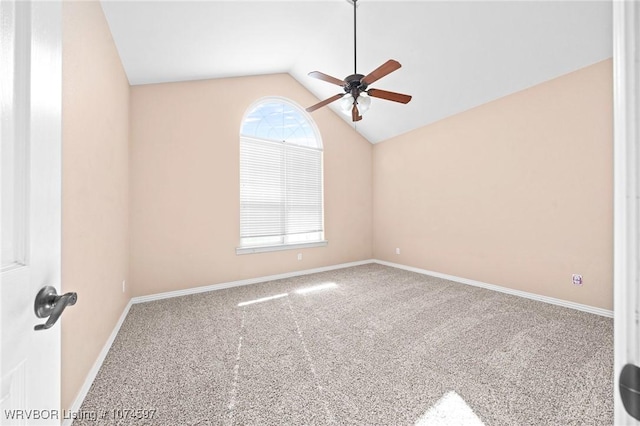 carpeted spare room featuring ceiling fan and lofted ceiling