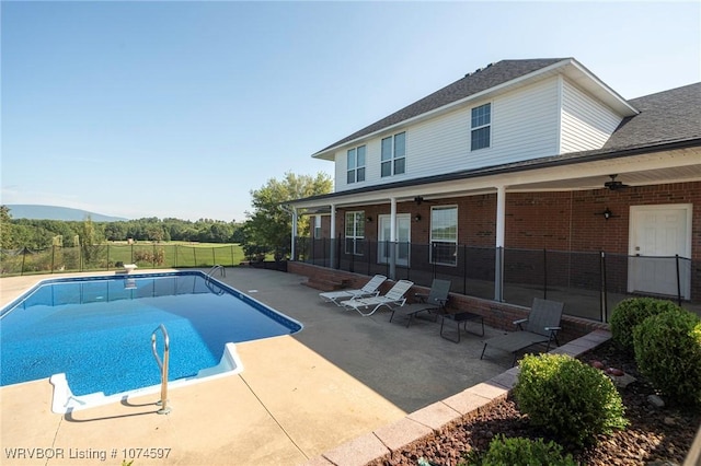 view of swimming pool featuring a diving board, ceiling fan, and a patio area