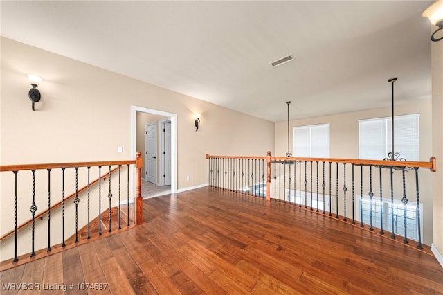 unfurnished room with a chandelier and wood-type flooring