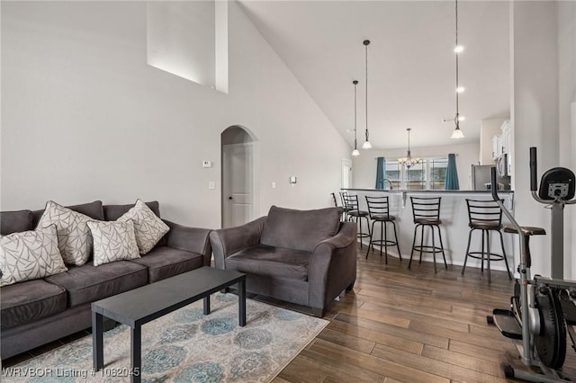 1138 Delta Dr, Van Buren, AR 72956 - living area with high vaulted ceiling, arched walkways, dark wood finished floors, and a chandelier