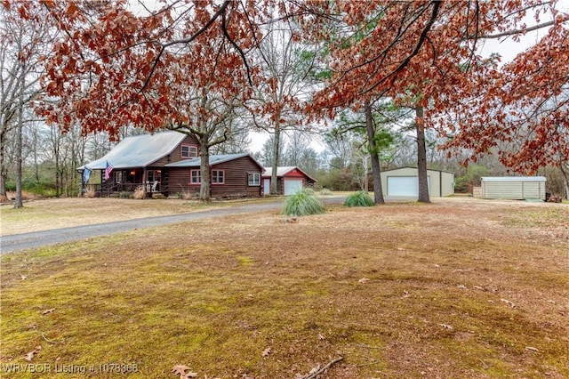 view of yard featuring a garage and an outbuilding