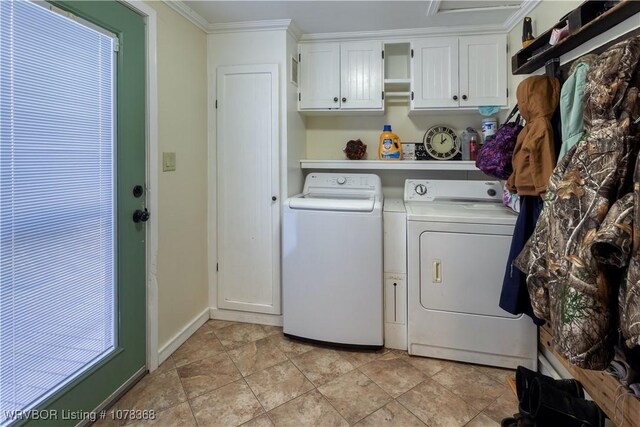 laundry room featuring washer and dryer, cabinets, and ornamental molding