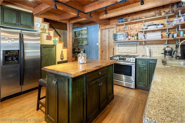 kitchen with wood ceiling, appliances with stainless steel finishes, sink, light stone counters, and beamed ceiling