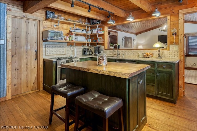 kitchen featuring a center island, light hardwood / wood-style flooring, appliances with stainless steel finishes, a kitchen breakfast bar, and wood ceiling