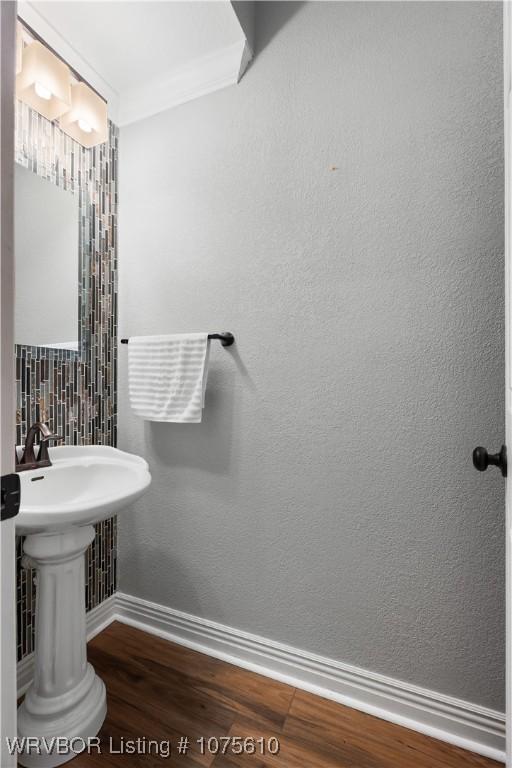 bathroom with hardwood / wood-style flooring and ornamental molding