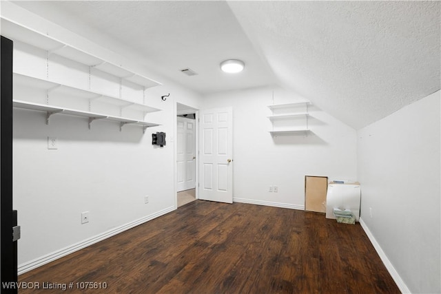 interior space with lofted ceiling, dark hardwood / wood-style flooring, and a textured ceiling