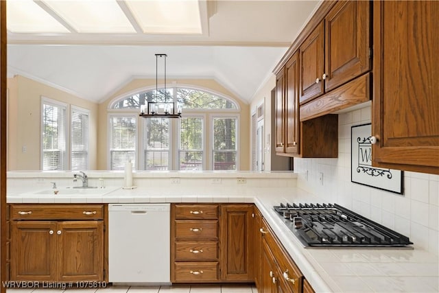 kitchen with an inviting chandelier, plenty of natural light, white dishwasher, lofted ceiling, and stainless steel gas stovetop