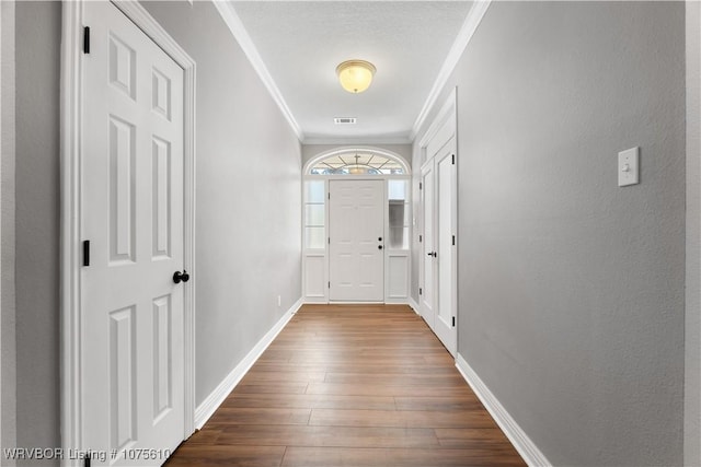 doorway to outside with dark hardwood / wood-style flooring and ornamental molding