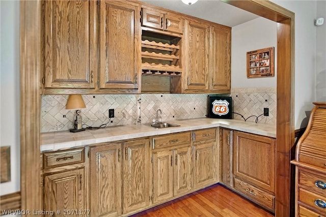 kitchen featuring tasteful backsplash, sink, and light hardwood / wood-style flooring