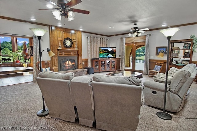 carpeted living room with ornamental molding, ceiling fan, and a healthy amount of sunlight