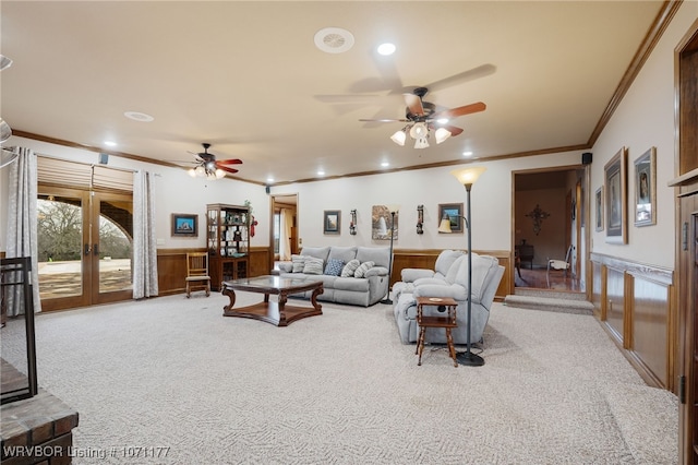 living room featuring french doors, light colored carpet, crown molding, and ceiling fan