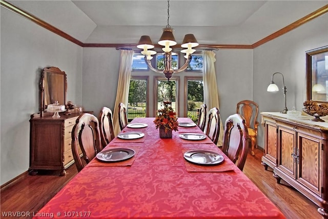 dining space featuring wood-type flooring, a tray ceiling, and a notable chandelier