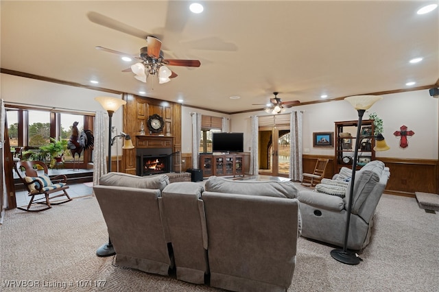 carpeted living room with ornamental molding and ceiling fan