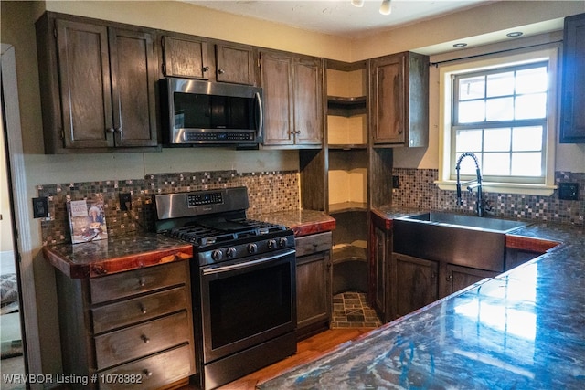 kitchen featuring appliances with stainless steel finishes, dark brown cabinets, backsplash, and sink