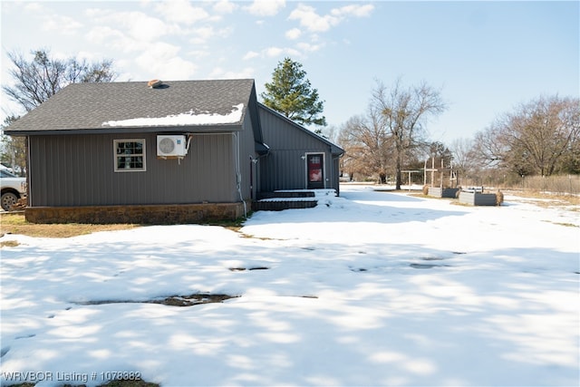 snow covered property with an AC wall unit