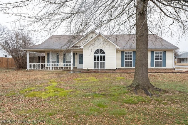 view of front of house featuring a porch, a shingled roof, and a front lawn