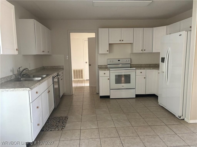 kitchen with sink, white cabinets, white appliances, and light tile patterned floors