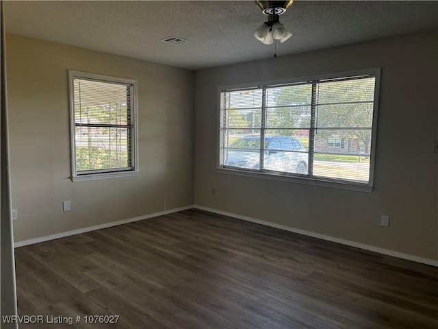 empty room featuring a textured ceiling, ceiling fan, and dark wood-type flooring