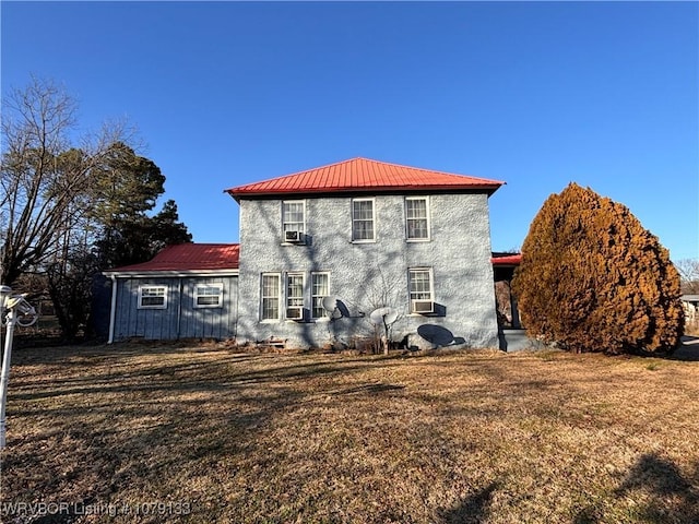 rear view of house with a yard and metal roof