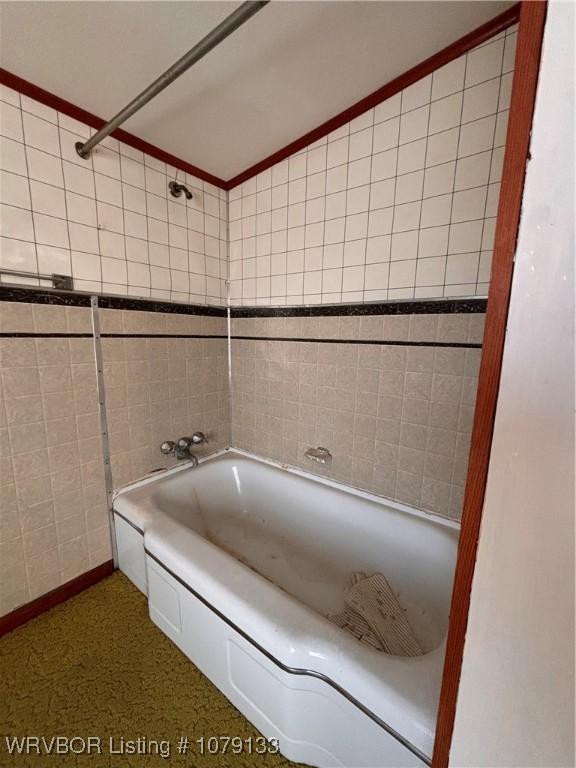 full bath with tile walls