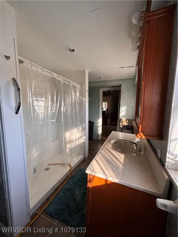 bathroom with a stall shower, tile patterned floors, and vanity