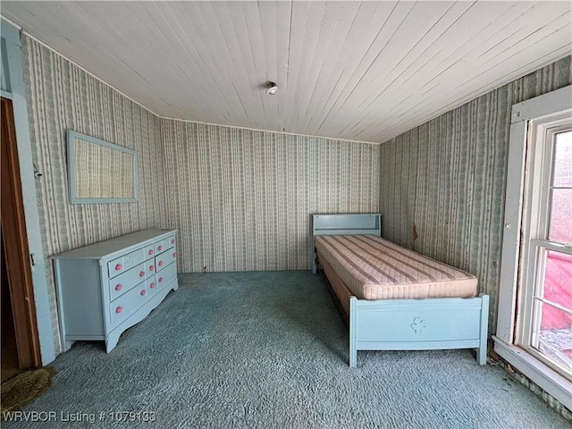 unfurnished bedroom with wallpapered walls and carpet flooring