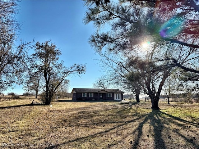 view of front of home with a front lawn and a rural view