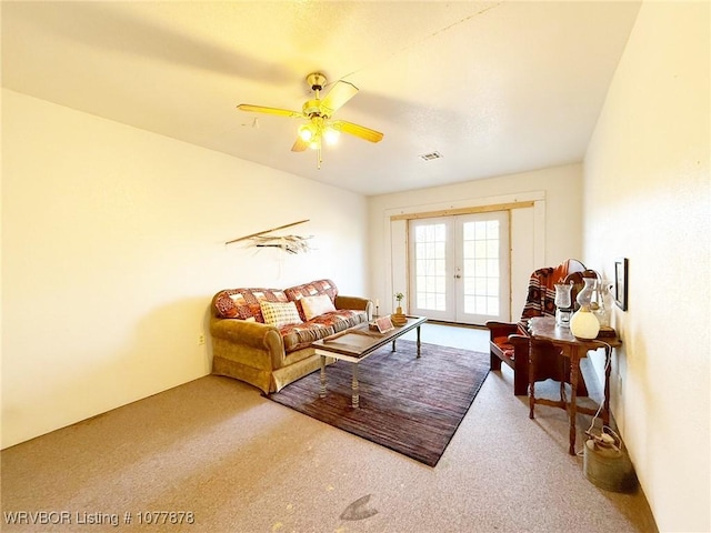 carpeted living room with french doors and ceiling fan