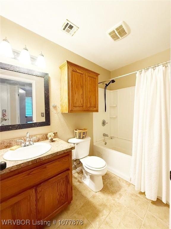 full bathroom with shower / tub combo with curtain, vanity, and toilet