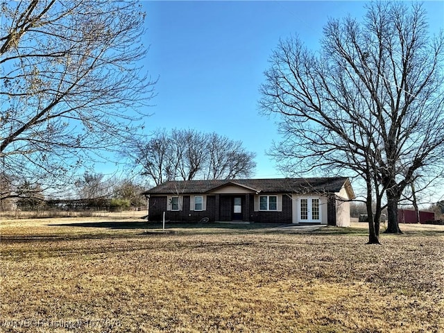 ranch-style home with french doors and a front lawn