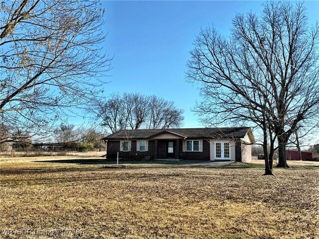 ranch-style home with french doors and a front lawn