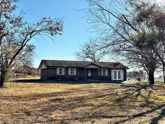 ranch-style home featuring french doors and a front yard