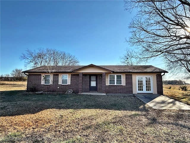 single story home with french doors and a front lawn