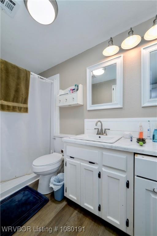 473413 E 1050th Rd, Muldrow, OK 74948 - bathroom featuring visible vents, vanity, wood finished floors, toilet, and a shower with shower curtain